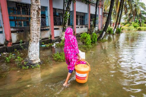 A woman collects essential relief items from an ActionAid distribution point in Noakhali Sadar District. 