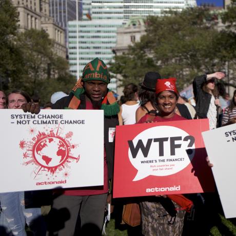 Protesters demanding climate justice holding banners which read 'system change, not climate change'