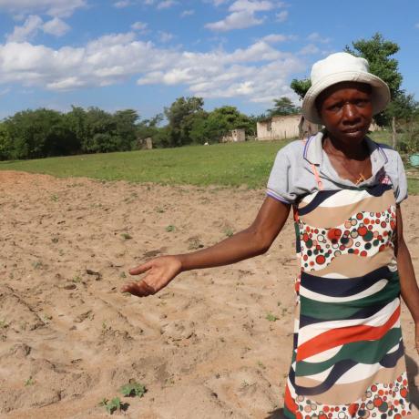 Photo shows a farmer in a barren field