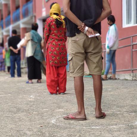 Residents of Kathmandu wait, socially distanced, at a food distribution, April 2020