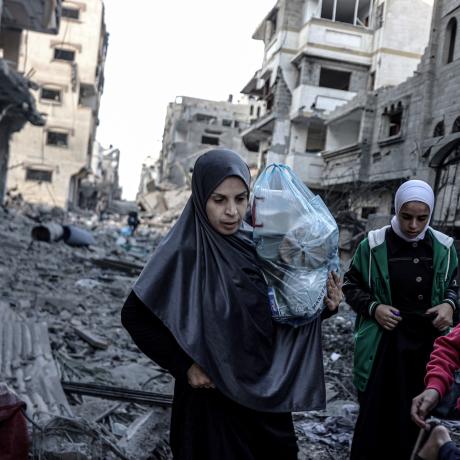 Palestinian women and children carrying belongings flee to safer areas following Israeli bombardments on southern part of Gaza City