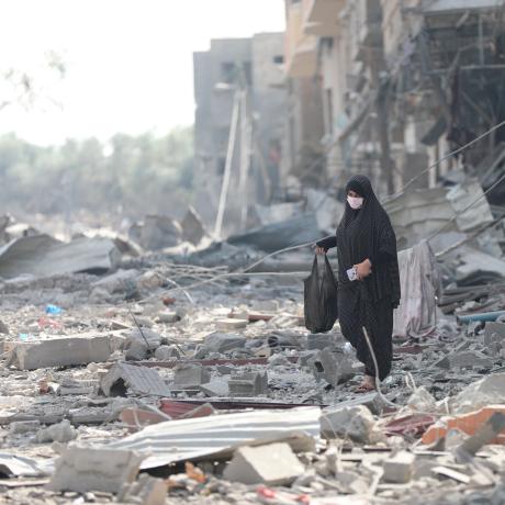 A woman resident of Gaza City searches the rubble for belongings in the aftermath of bombing by the Israeli army.