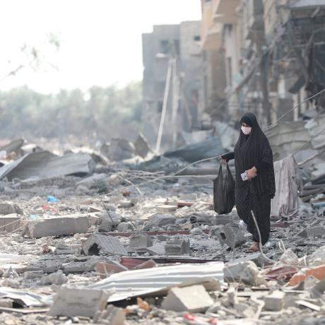 A woman resident of Gaza City searches the rubble for belongings in the aftermath of bombing by the Israeli army.