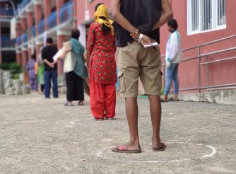 Residents of Kathmandu wait, socially distanced, at a food distribution, April 2020